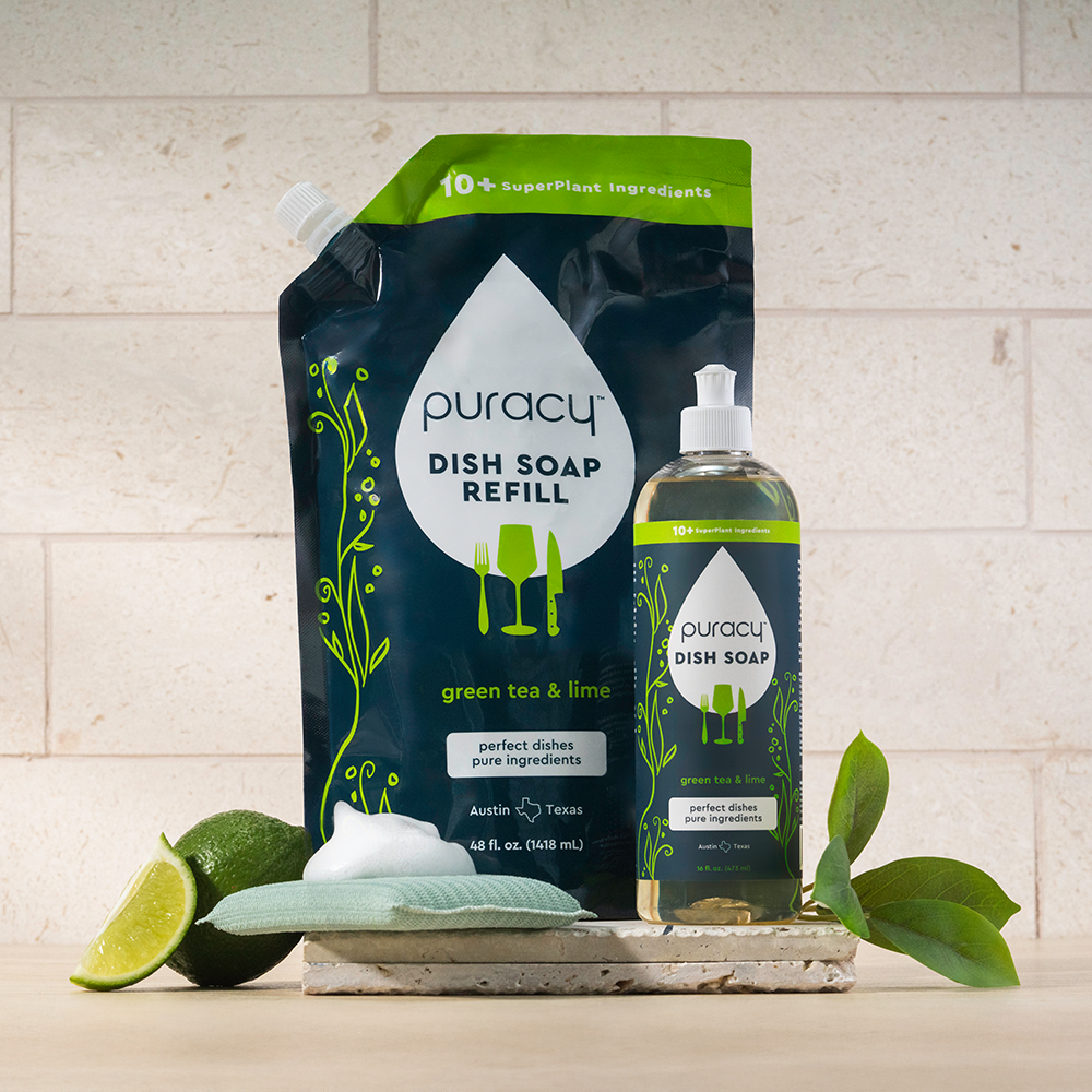 Puracy dish soap refill pack and bottle on a kitchen counter with lime slices and leaves.