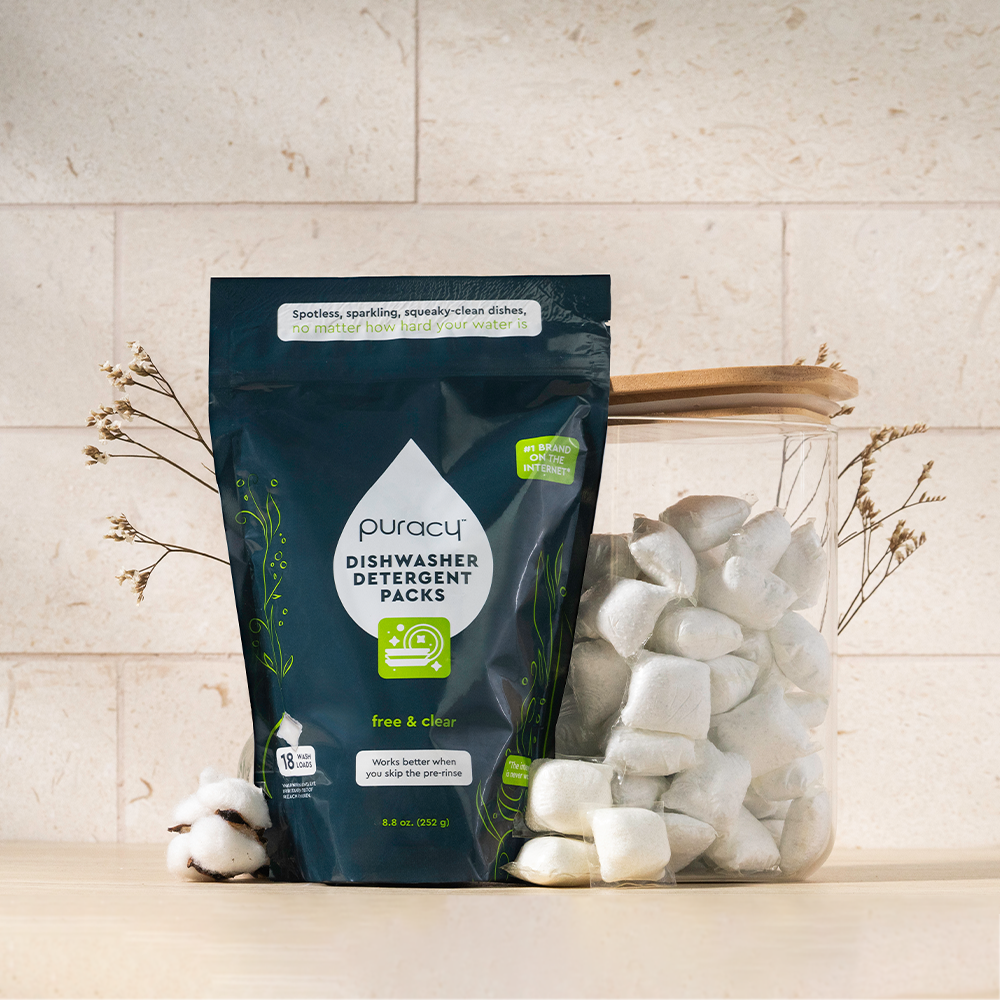 Puracy dishwasher detergent packs on a kitchen counter with a light background