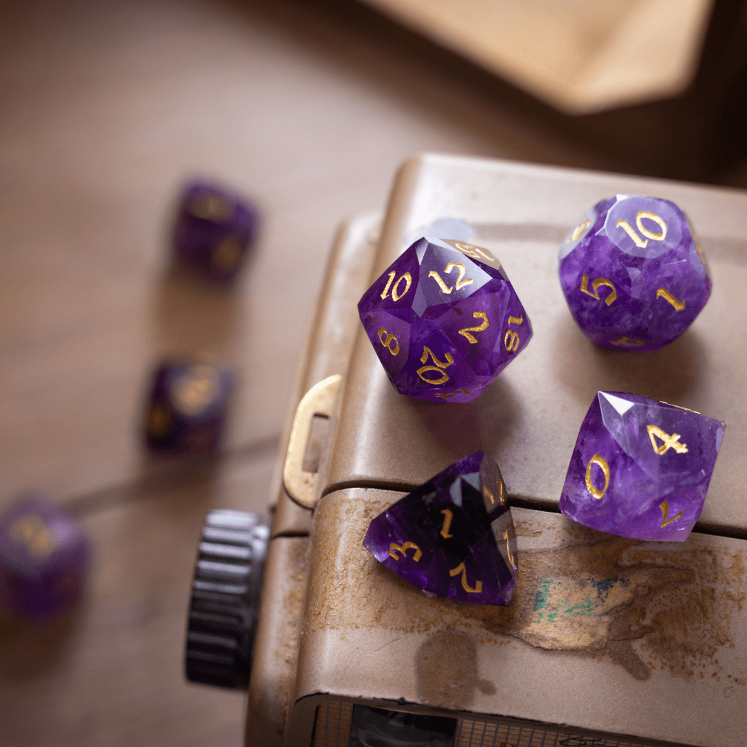 Purple polyhedral dice with gold numbers on a worn book