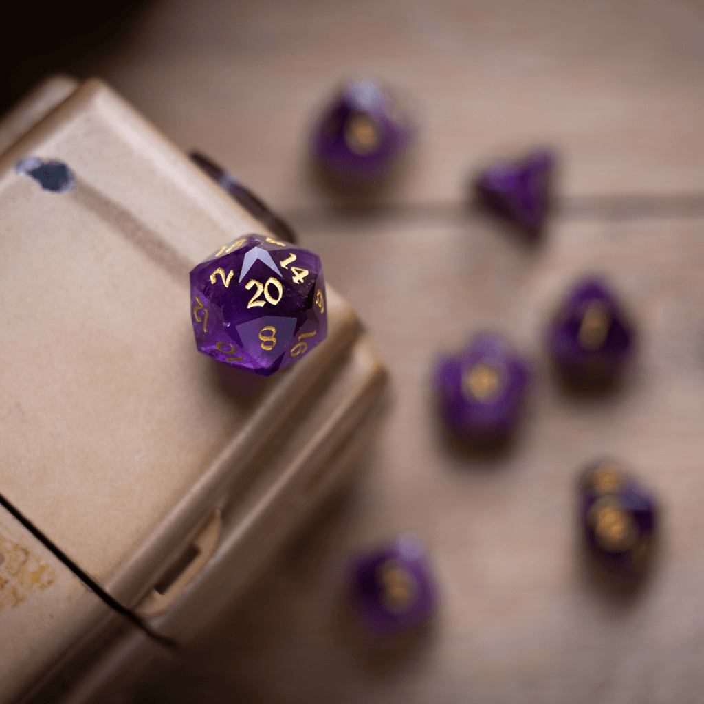 Purple polyhedral dice with gold numbers on a wooden surface