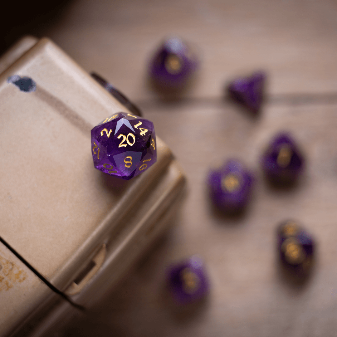 Purple polyhedral dice with gold numbers on a wooden surface