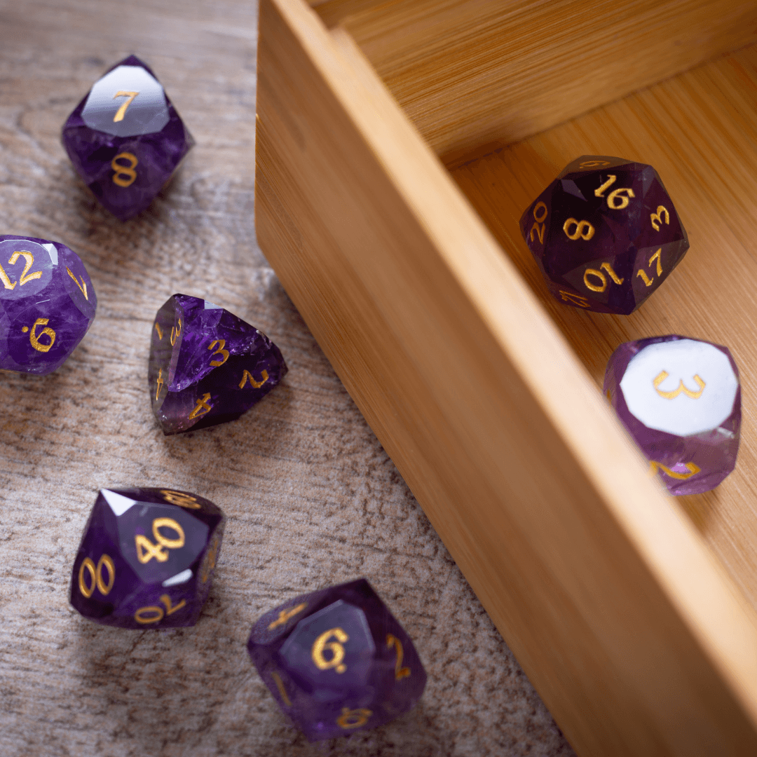 Purple polyhedral dice with gold numbers on a wooden surface