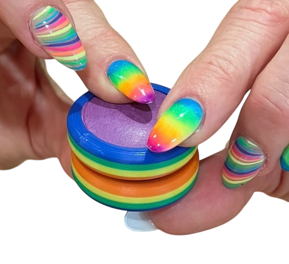 Colorful striped ring held by a hand with rainbow nail polish on a white background