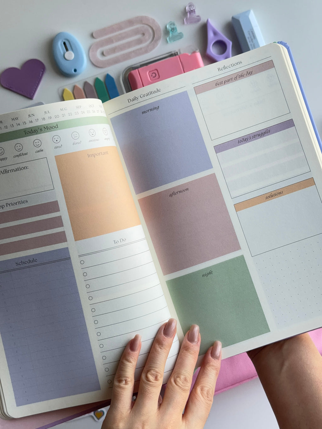 Open planner with colorful stickers and a hand holding it