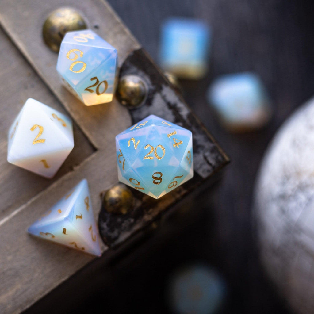 Set of polyhedral dice with gold numbers on a dark surface