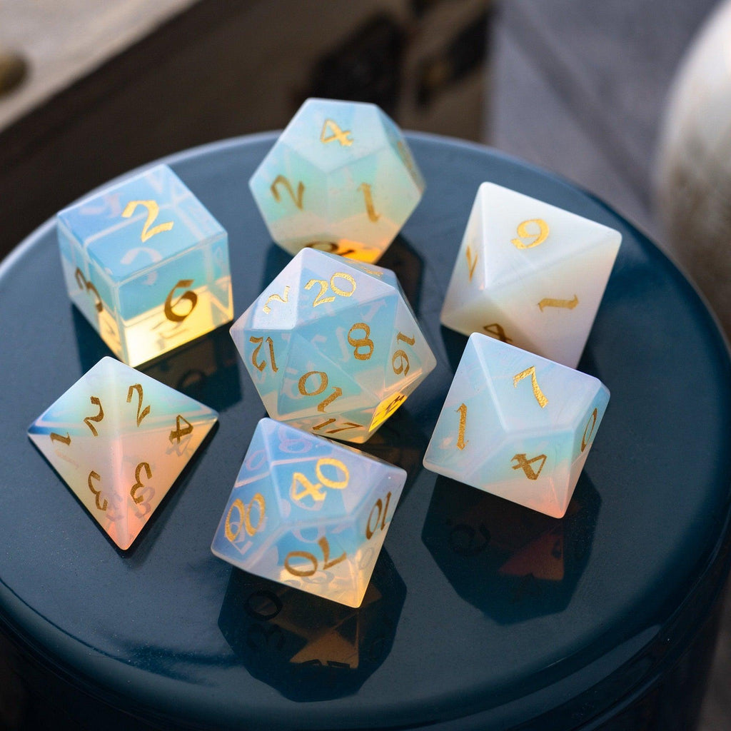 Set of colorful polyhedral dice with gold numbers on a reflective surface