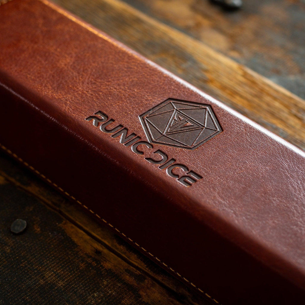 Brown leather dice case with 'Runic Dice' logo on a wooden surface