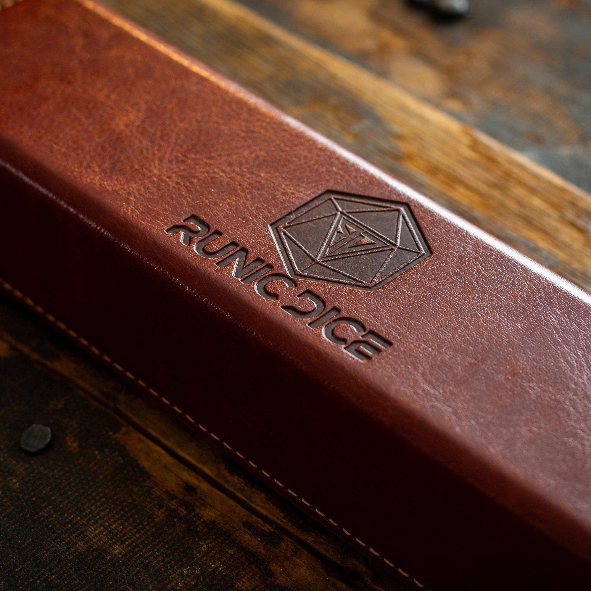 Brown leather dice case with 'Runic Dice' logo on a wooden surface