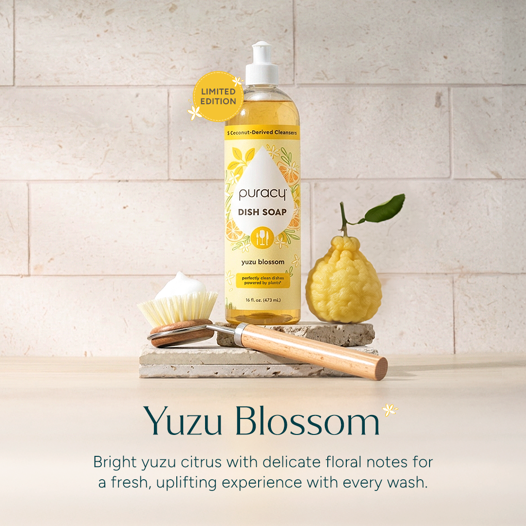 Bottle of puracy dish soap with yuzu blossom scent on a stone surface.