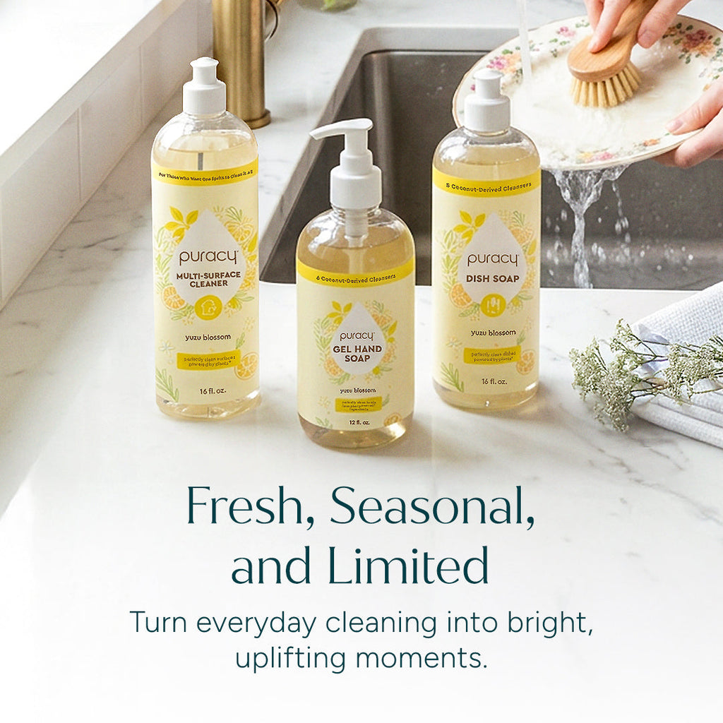 Three bottles of Puracy cleaning products on a kitchen counter with a sink in the background.