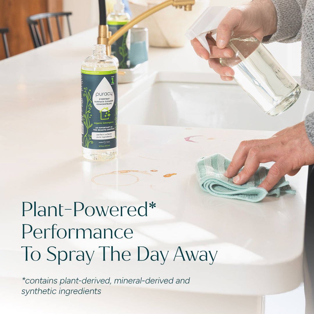 Person cleaning a table with a cloth, next to a bottle of Puracy cleaning solution.