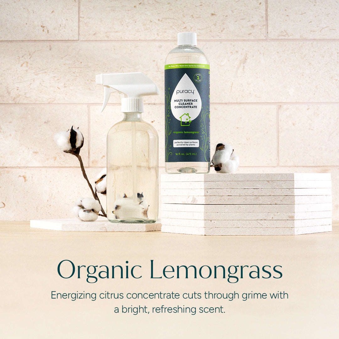 Bottle of Pura+ multi-surface cleaner concentrate with a spray bottle on a wooden surface.
