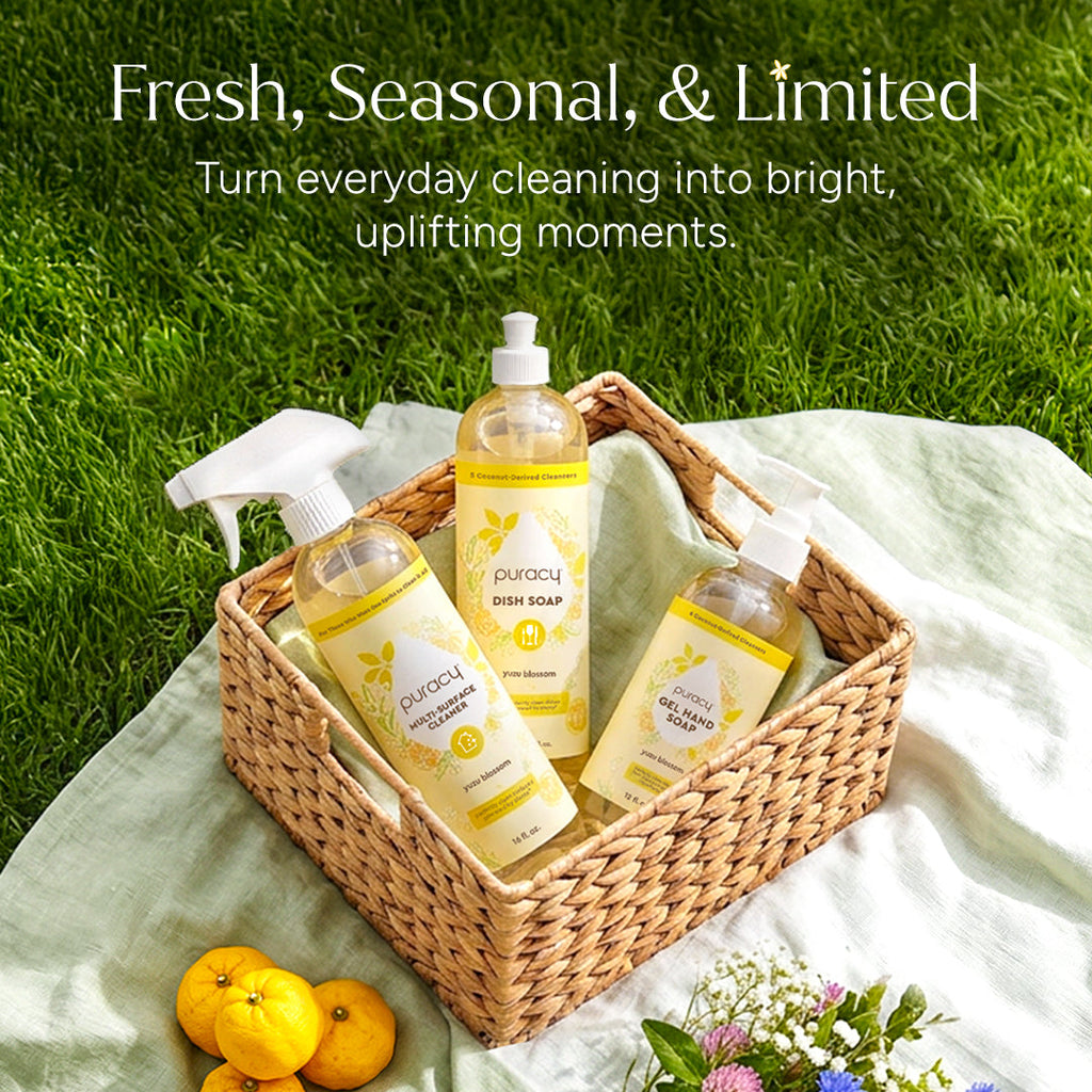 Puracy cleaning products in a basket with lemons and flowers on a grassy background