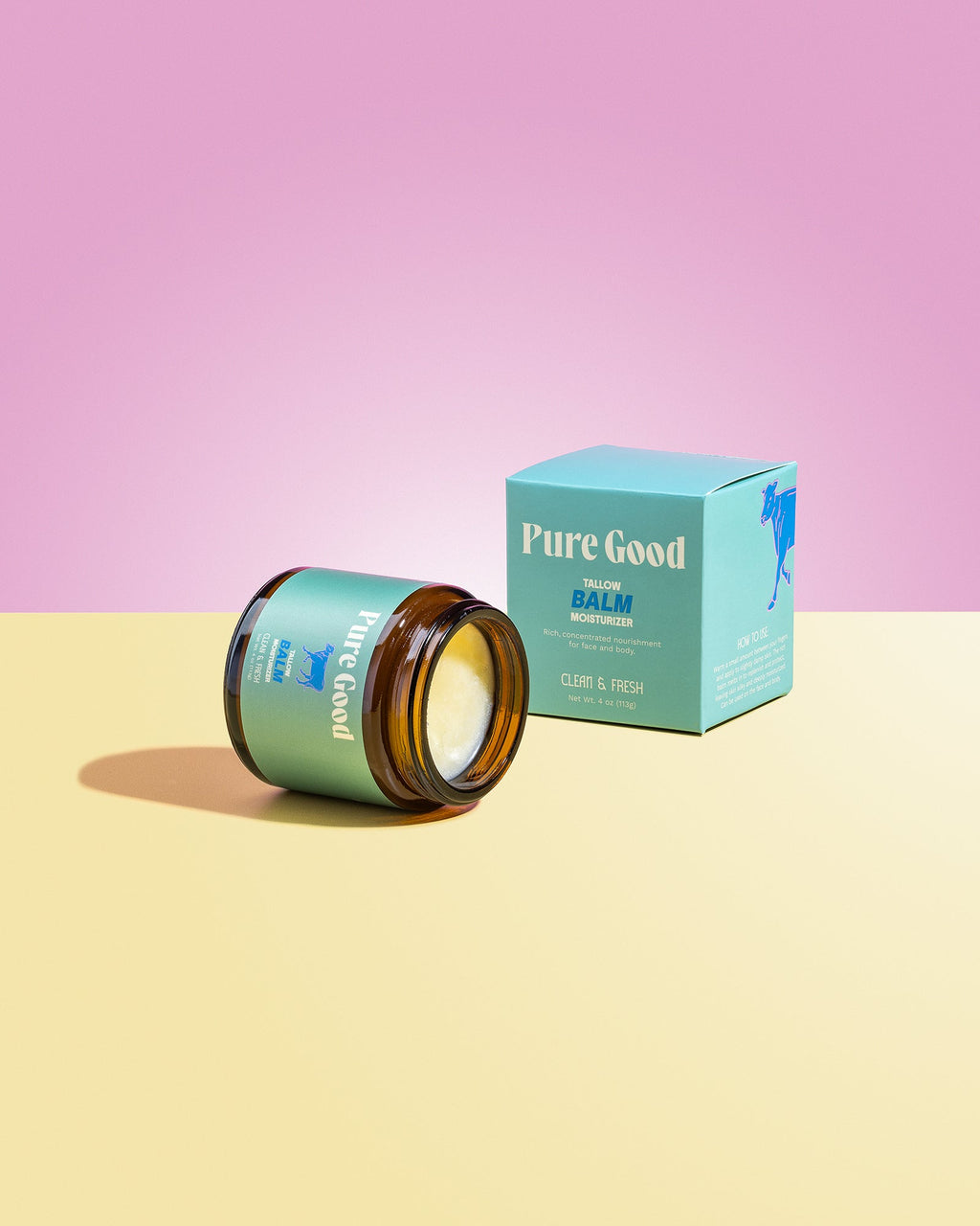 Jar of 'Pure Good' balm with a matching box on a pink and yellow gradient background