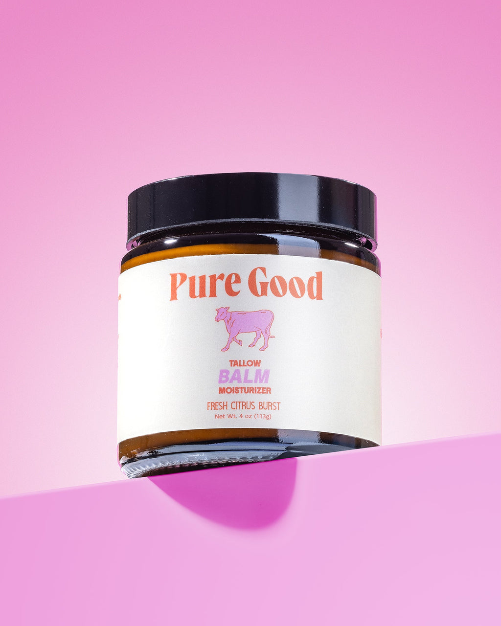 Jar of 'Pure Good' balm on a pink background