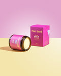 Pink 'Pure Good' balm jar and box on a pink and yellow gradient background