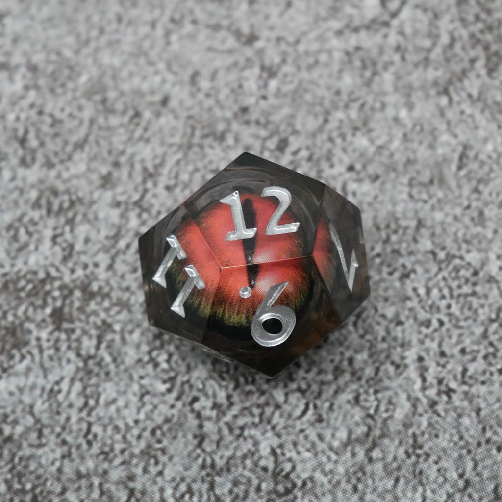 Dodecahedral dice with red and black design on a textured gray surface