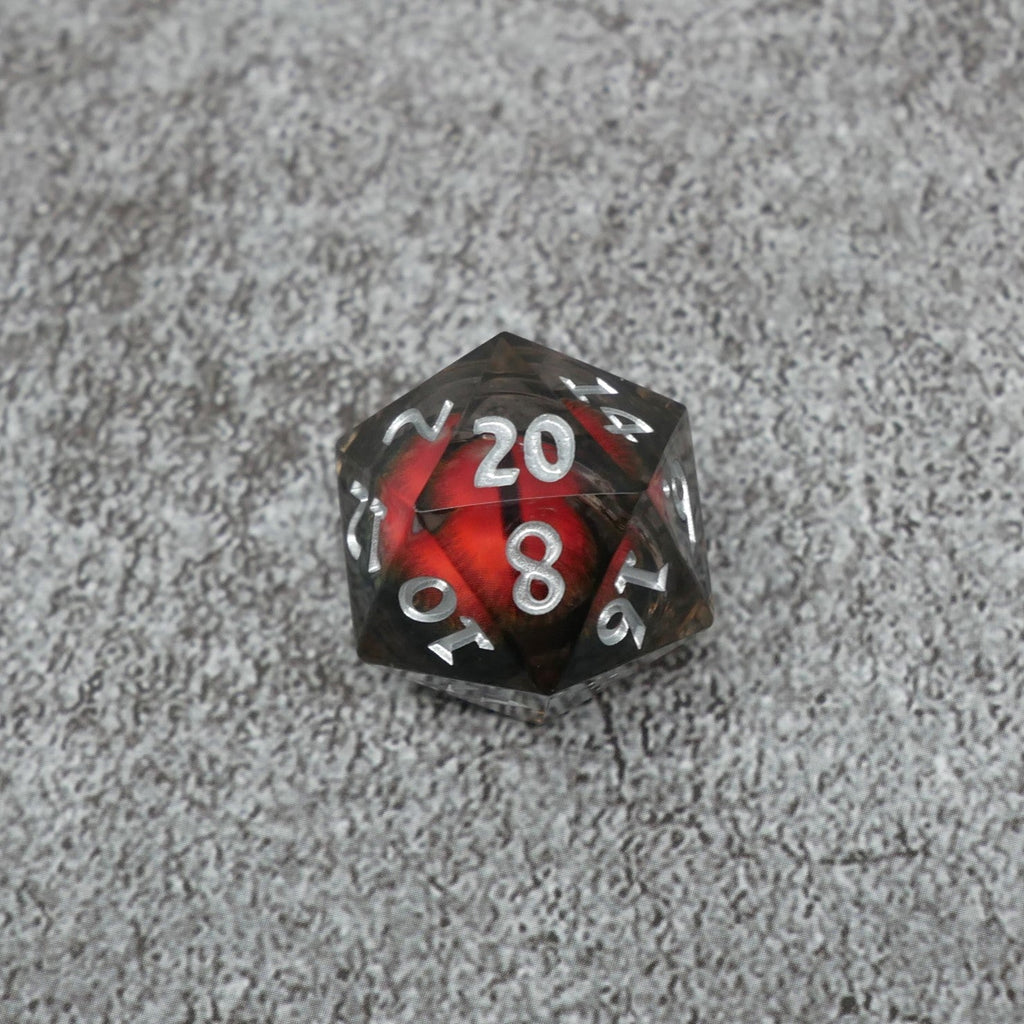 D20 polyhedral dice with red and black design on a gray surface