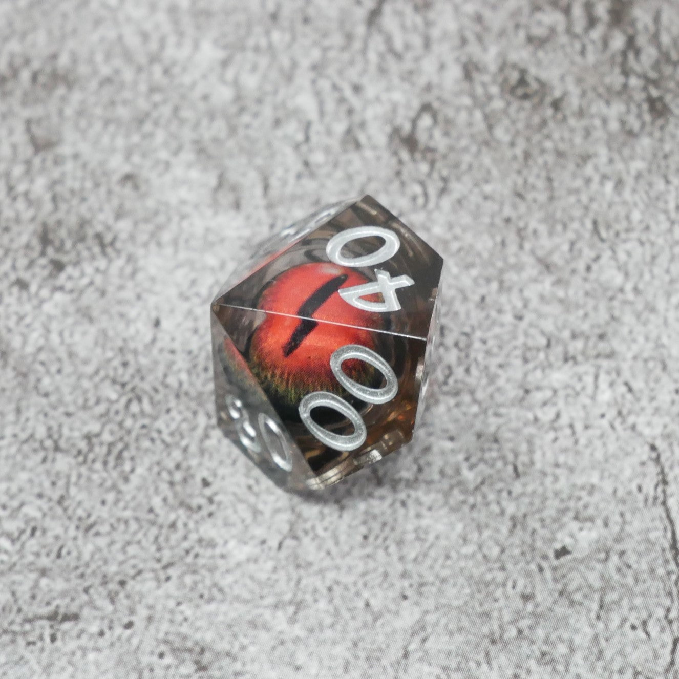 Dice with red and black design on a textured gray surface