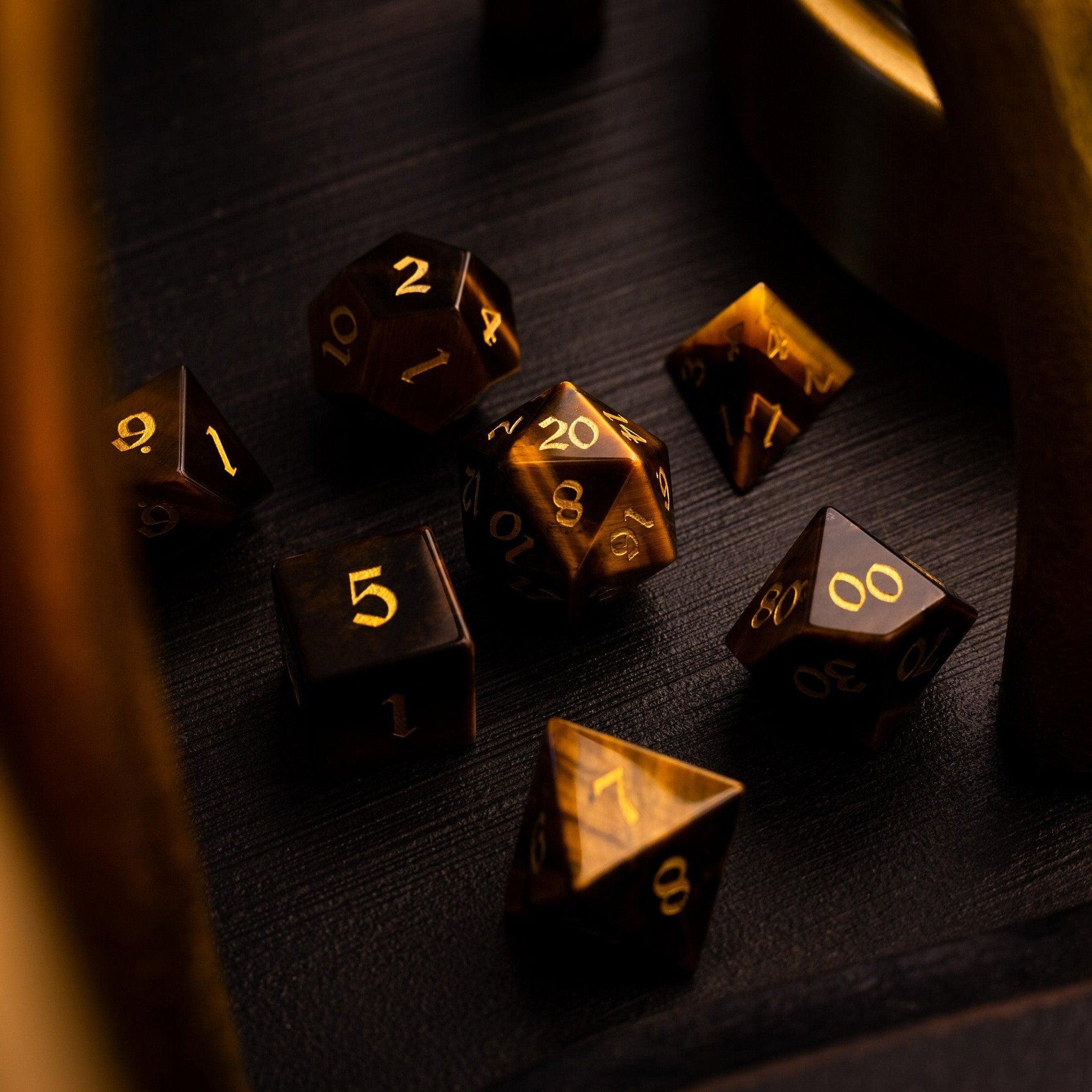 Gold polyhedral dice on a dark wooden surface