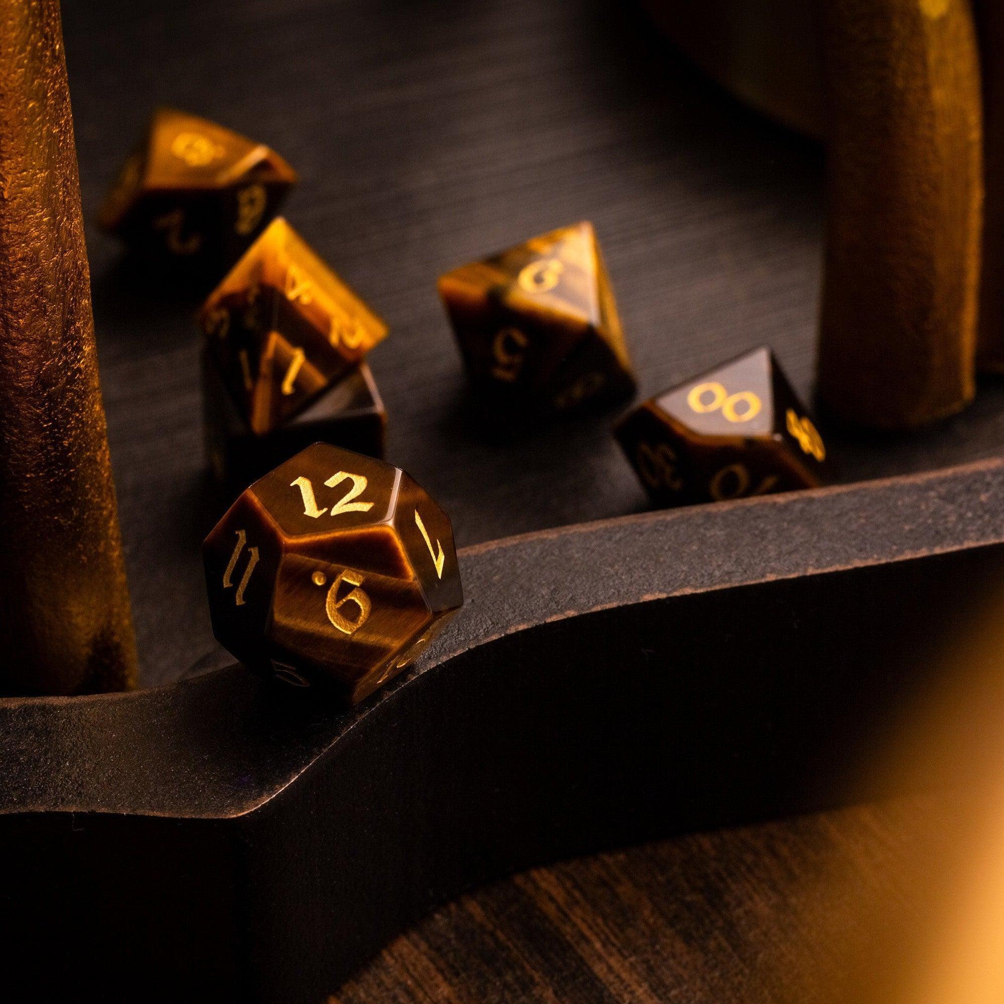 Set of metallic polyhedral dice with gold numbers on a dark surface