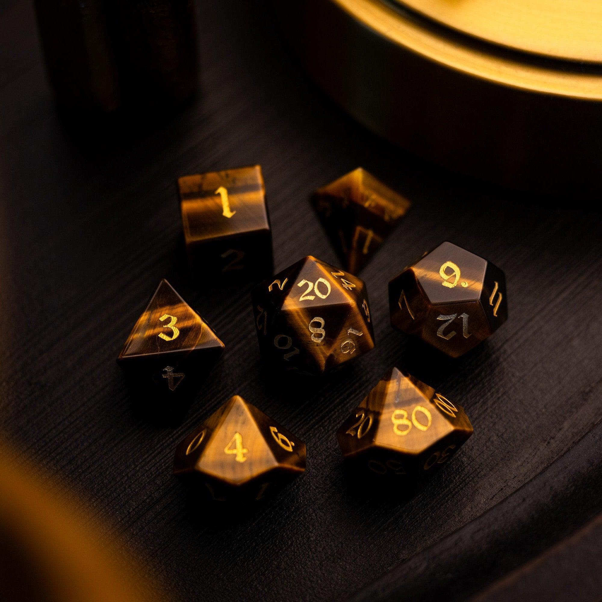 Set of metallic polyhedral dice on a dark surface