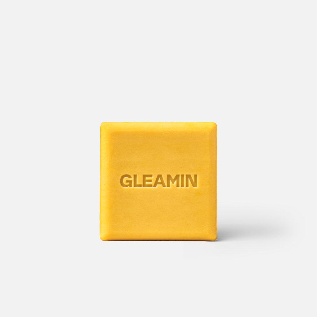 Yellow bar of soap with 'GLEAMIN' branding on a white background