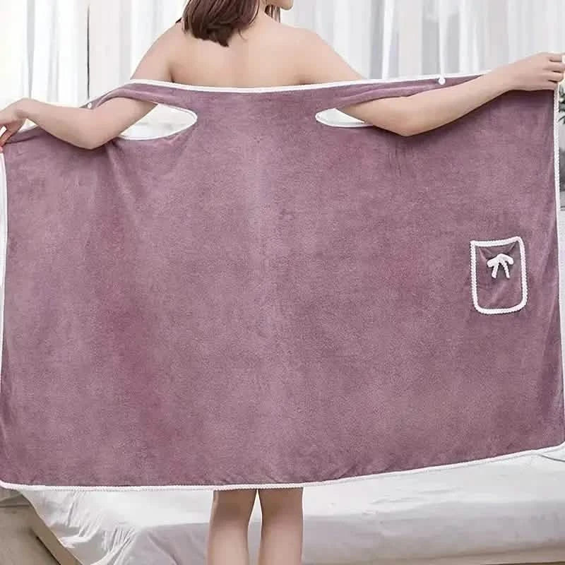 Person holding a large purple towel with a white logo on a white background