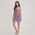 Woman wearing a purple sleeveless dress with white trim on a plain background