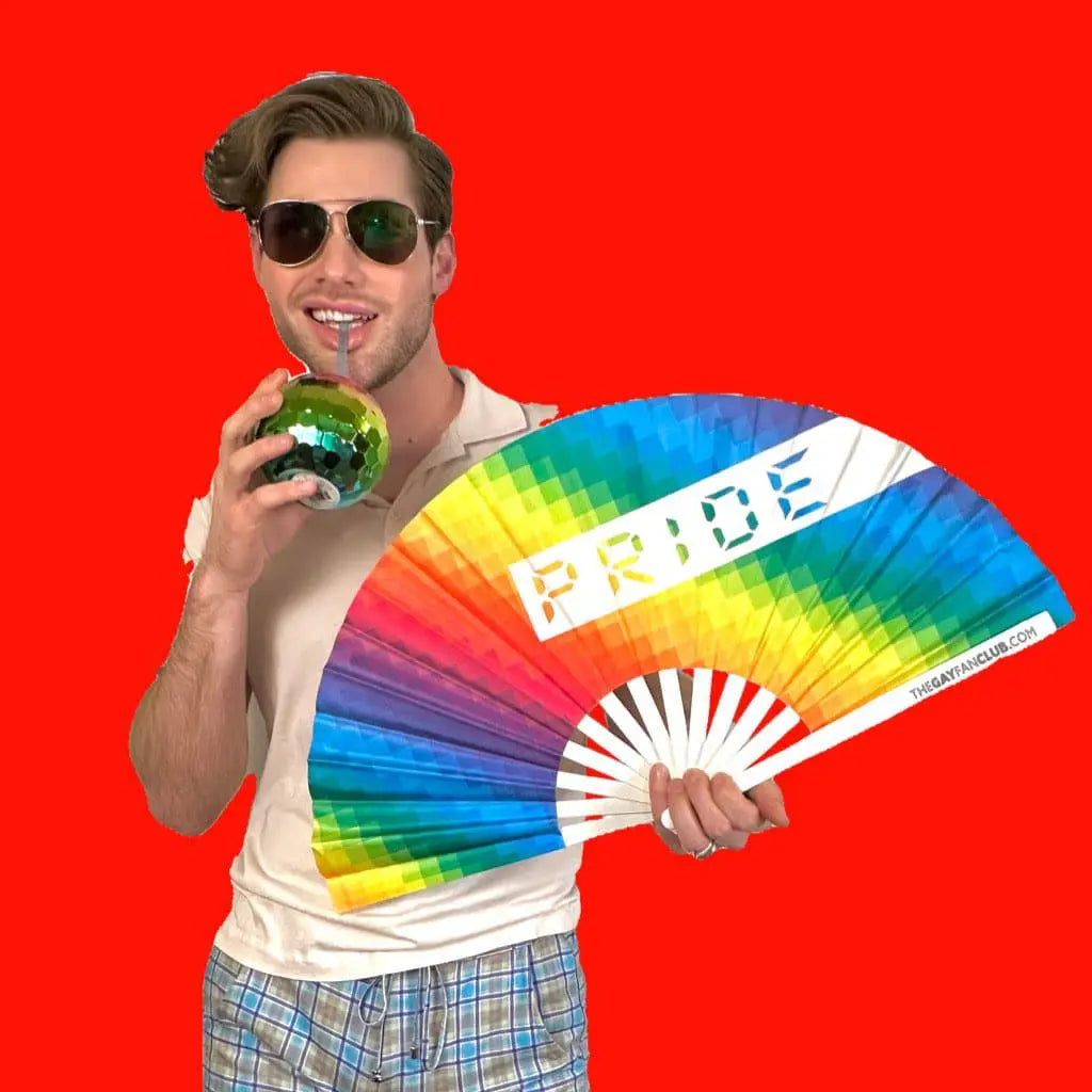 Man holding a rainbow fan with 'PRIDE' text against a red background