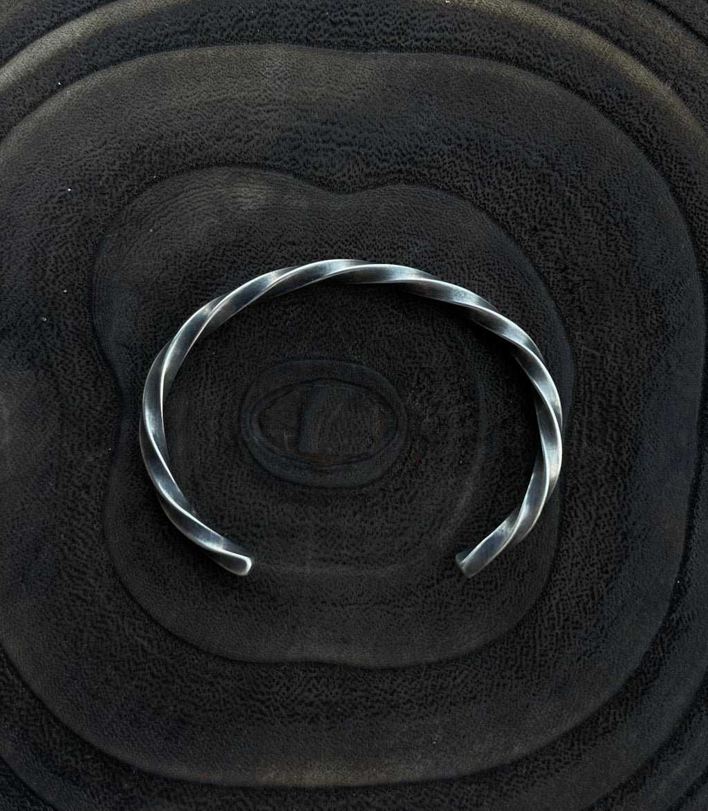 Silver bracelet on a textured black surface