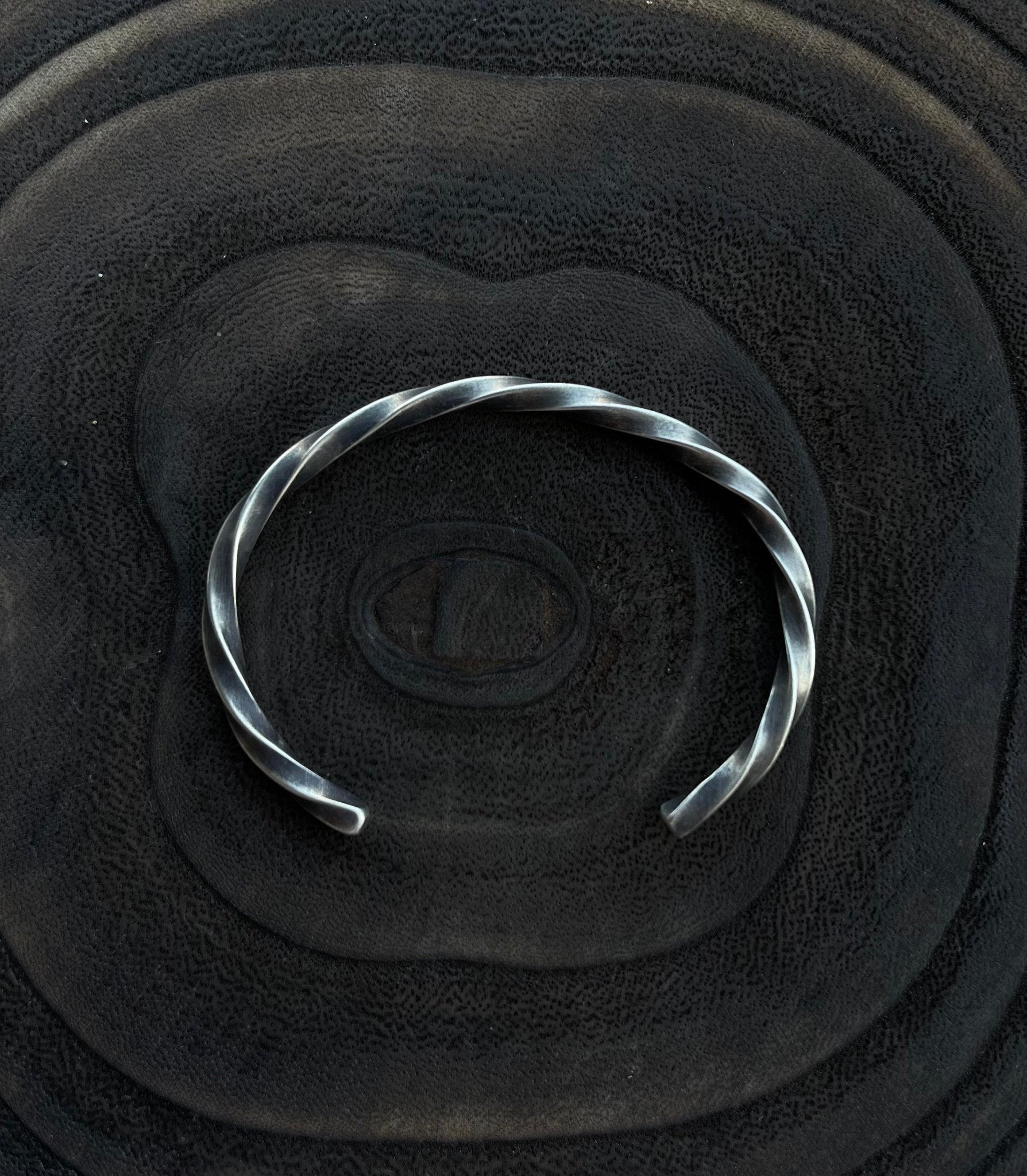 Silver bracelet on a textured black surface
